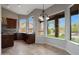 Bright kitchen featuring dark wood cabinets, marble countertops, and large windows at 6672 E Horned Owl Trl, Scottsdale, AZ 85266