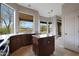 Bright kitchen featuring an island, dark wood cabinets, marble countertops, and large windows at 6672 E Horned Owl Trl, Scottsdale, AZ 85266
