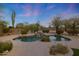 Backyard oasis with a beautiful pool, waterfall feature, and lush desert landscaping at 6672 E Horned Owl Trl, Scottsdale, AZ 85266