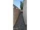 Narrow side yard with gravel, enclosed by block fencing providing privacy at 6722 W Shannon St, Chandler, AZ 85226