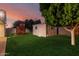 Landscaped backyard with a shed and a wooden playhouse on a lush green lawn at 728 E State Ave, Phoenix, AZ 85020