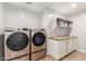Well-equipped laundry room with washer, dryer, counter space and storage cabinets creating an efficient space at 728 E State Ave, Phoenix, AZ 85020