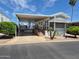 Desirable mobile home featuring a covered carport with seating area and front steps with lovely landscaping at 7750 E Broadway Rd # 361, Mesa, AZ 85208