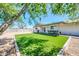 Well-maintained backyard with artificial grass, gravel accents, and a covered patio area at 8 S Cholla St, Gilbert, AZ 85233