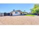 Spacious backyard featuring gravel landscaping, an artificial grass area, and a covered patio at 8 S Cholla St, Gilbert, AZ 85233