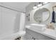 Cozy bathroom with a single sink vanity, round mirror, and a bathtub with a shower at 8 S Cholla St, Gilbert, AZ 85233
