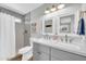 Bright bathroom with a double sink vanity, framed mirrors, and a shower with white tile at 8 S Cholla St, Gilbert, AZ 85233