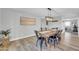 Bright dining room features a rustic wood table, black chairs, decorative light fixture and wood tile flooring at 8 S Cholla St, Gilbert, AZ 85233