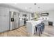 Modern kitchen with gray cabinets, stainless appliances, center island with bar seating, and wood tile flooring at 8 S Cholla St, Gilbert, AZ 85233