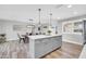 Modern kitchen and dining featuring gray cabinets, stainless appliances, center island, and wood tile flooring at 8 S Cholla St, Gilbert, AZ 85233