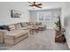 Spacious living room featuring plush gray sofa, neutral carpet, and mounted flatscreen television at 8 S Cholla St, Gilbert, AZ 85233