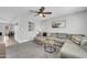 Comfortable living room features plush gray sofa, ceiling fan, and view of the dining room at 8 S Cholla St, Gilbert, AZ 85233