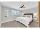 Comfortable bedroom with plush carpeting, ceiling fan, and a picture window at 8 S Cholla St, Gilbert, AZ 85233