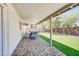 Relaxing covered patio with paved flooring, dining set, and a view of the artificial grass yard at 8 S Cholla St, Gilbert, AZ 85233