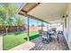 Inviting covered patio with a dining set, barbecue grill, and views of the artificial grass backyard at 8 S Cholla St, Gilbert, AZ 85233