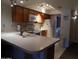 Well-lit kitchen featuring white countertops, tile floors, and wooden cabinets, with an adjacent laundry area at 8651 E Royal Palm Rd # 118, Scottsdale, AZ 85258