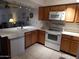 A well-maintained kitchen featuring white appliances, ample counter space, and wooden cabinetry at 8651 E Royal Palm Rd # 118, Scottsdale, AZ 85258