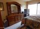 Bedroom features a large wood dresser with a decorative mirror and sliding doors to the balcony at 8651 E Royal Palm Rd # 118, Scottsdale, AZ 85258