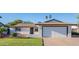 Charming single-story home with a well-maintained lawn, a two-car garage, and mature trees at 8716 E Mitchell Dr, Scottsdale, AZ 85251