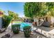 Beautiful backyard featuring a sparkling pool, mature trees, and a manicured lawn at 9203 S Heather Dr, Tempe, AZ 85284