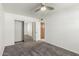 Neutral-toned bedroom featuring carpet, a fan, mirrored closet doors, and an entryway into another room at 9203 S Heather Dr, Tempe, AZ 85284