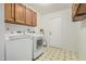 Functional laundry room with washer, dryer, cabinets, and tiled floor at 9203 S Heather Dr, Tempe, AZ 85284