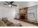 Cozy living room featuring a brick fireplace, ceiling fan, and neutral colored sofa at 9203 S Heather Dr, Tempe, AZ 85284