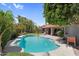 Inviting backyard pool with patio area, lush landscaping, and a clear blue sky at 9203 S Heather Dr, Tempe, AZ 85284