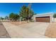 Street-level view of a gray single-story home with desert landscaping, a garage, and a long driveway at 9203 S Heather Dr, Tempe, AZ 85284