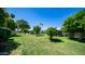 Expansive backyard with mature trees, a well-manicured lawn, and ample space for outdoor activities at 9911 W Pleasant Valley Rd, Sun City, AZ 85351