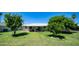 Expansive backyard with lush lawn, mature trees, and covered patio for outdoor enjoyment at 9911 W Pleasant Valley Rd, Sun City, AZ 85351