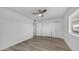 Well-lit bedroom features wood-look flooring, ceiling fan, and closet for storage at 9911 W Pleasant Valley Rd, Sun City, AZ 85351