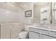 Clean bathroom with walk-in tub, white toilet, and gray vanity with crystal knobs at 10311 E Trent Ave, Mesa, AZ 85212