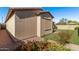 Exterior corner of a home featuring decorative flower beds, a walkway, and a privacy wall at 10311 E Trent Ave, Mesa, AZ 85212