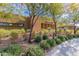 Community clubhouse exterior featuring desert landscaping and a sign between mature trees at 10311 E Trent Ave, Mesa, AZ 85212