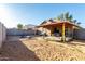 Spacious backyard featuring a covered patio, barbecue grill, and potential for landscaping at 13159 W Caribbean Ln, Surprise, AZ 85379