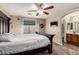 Spacious bedroom showcasing a dark wood bed frame and an attached bathroom for added convenience at 13159 W Caribbean Ln, Surprise, AZ 85379