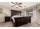 Bedroom with a large dark wood bed frame, ceiling fan, and natural light from a window at 13159 W Caribbean Ln, Surprise, AZ 85379