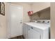 Laundry room with appliances and a shelf for storage, providing a functional space for chores at 13159 W Caribbean Ln, Surprise, AZ 85379