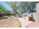 Backyard boasts a built-in grill area, lush trees, and a charming fire pit space at 13261 W Gelding W Cir, Surprise, AZ 85379
