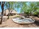 Expansive backyard offers a fire pit, mature trees, and plenty of space for outdoor enjoyment at 13261 W Gelding W Cir, Surprise, AZ 85379