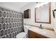 Well-lit bathroom featuring a vanity with wood cabinets, an updated sink, and a decorative shower curtain at 13261 W Gelding W Cir, Surprise, AZ 85379