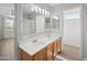 Bright bathroom features double sinks, wood cabinets, and a well-lit vanity mirror at 13261 W Gelding W Cir, Surprise, AZ 85379