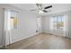 Bright bedroom featuring a ceiling fan, wood-look flooring, and ample light at 13261 W Gelding W Cir, Surprise, AZ 85379