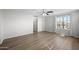 Bright bedroom with wood-look floors, a ceiling fan, and a view of the neighborhood at 13261 W Gelding W Cir, Surprise, AZ 85379