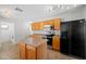 Kitchen featuring wooden cabinets, black appliances, tile floors, and a center island at 13261 W Gelding W Cir, Surprise, AZ 85379
