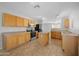 Kitchen featuring wooden cabinets, black appliances, tile floors, and a center island at 13261 W Gelding W Cir, Surprise, AZ 85379