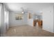 Open-concept living room featuring tile floors, natural lighting, and a ceiling fan at 13261 W Gelding W Cir, Surprise, AZ 85379