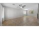 Open-concept living room with tile flooring, neutral walls, and ceiling fans, offering a bright and airy space at 13261 W Gelding W Cir, Surprise, AZ 85379