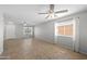 Spacious living room with tile flooring, ceiling fan, and ample natural light from multiple windows at 13261 W Gelding W Cir, Surprise, AZ 85379